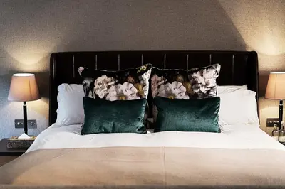 a bed with green pillows and a black headboard at Hotel du Vin & Bistro Cambridge in Cambridge