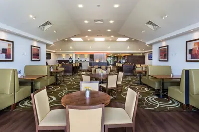 a dining room with tables and chairs in a restaurant at Holiday Inn Express Colchester by IHG in Colchester