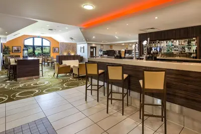 a bar in a restaurant with chairs and a counter at Holiday Inn Express Colchester by IHG in Colchester