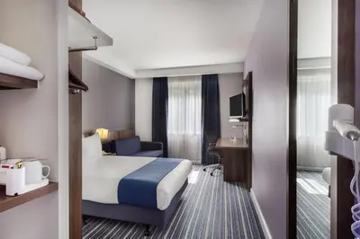 a hotel room with a large bed and a desk at Holiday Inn Express Colchester by IHG in Colchester