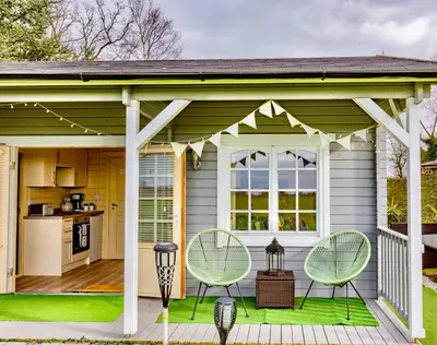 a house with two chairs and a patio at The Retreat Log Cabin in Sudbury