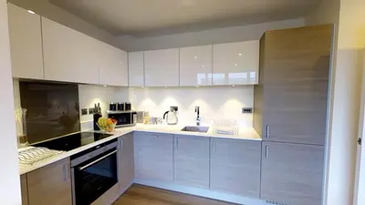 a kitchen with white cabinets and a stove top oven at Signet Apartments - Ceres in Cambridge