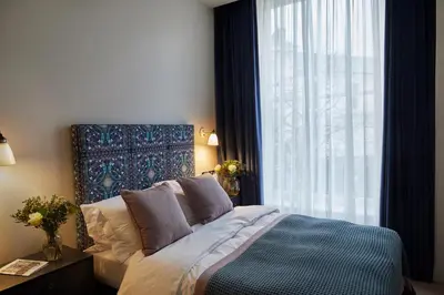 a bedroom with a bed and a large window at Hertford House in Hertford