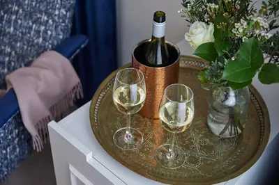 a table with a bottle of wine and two wine glasses at Hertford House in Hertford