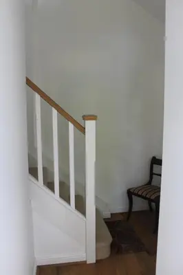 a staircase in a room with a chair at Pear Tree House Studio in Ely