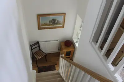 a hallway with stairs and a picture on the wall at Pear Tree House Studio in Ely