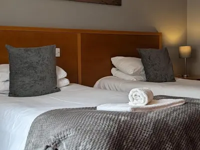 a hotel room with two beds with towels on the bed at The Earl Of Derby in Cambridge