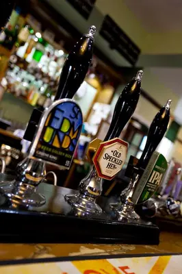 a counter with three bottles of beer in a bar at The Earl Of Derby in Cambridge