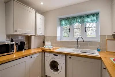 a kitchen with a sink and a washing machine at 1 Roseanna Cottage, Middleton - Aldeburgh Coastal Cottages in Middleton