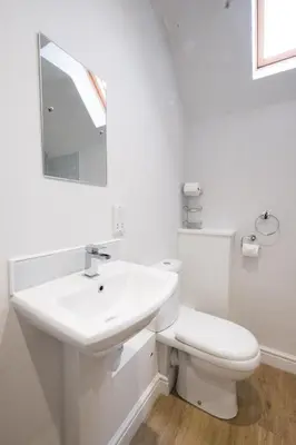 a white bathroom with a sink and a toilet at 1 Roseanna Cottage, Middleton - Aldeburgh Coastal Cottages in Middleton