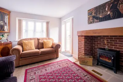 a living room with a couch and a fireplace at 1 Roseanna Cottage, Middleton - Aldeburgh Coastal Cottages in Middleton