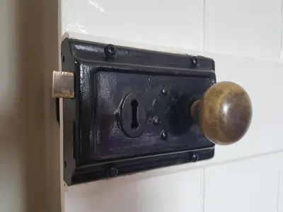 an open door with a brass knob on a wall at Flint Cottage in Brandon