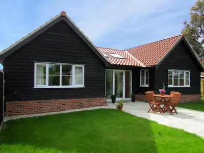 a black house with a red roof at 2 Suffolk Cottage, Knodishall - Aldeburgh Coastal Cottages in Aldringham