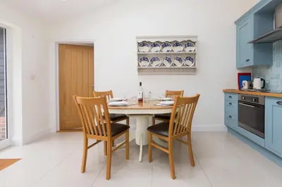 a kitchen with a table and chairs in a room at 2 Suffolk Cottage, Knodishall - Aldeburgh Coastal Cottages in Aldringham