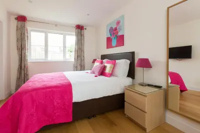 a bedroom with a large bed and a mirror at 2 Suffolk Cottage, Knodishall - Aldeburgh Coastal Cottages in Aldringham