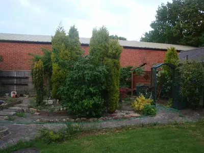 a garden in front of a brick building at Remarc Guest House in Takeley
