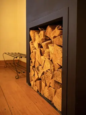 a pile of fire wood inside of a fireplace at All Seasons Cottage Breaks in Saxmundham