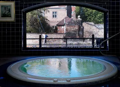 a large tub in a bathroom with a window at The Varsity Hotel & Spa in Cambridge