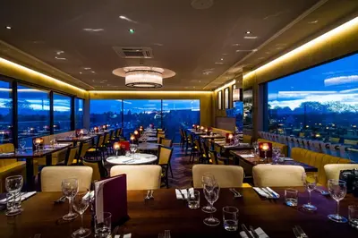 a restaurant with tables and chairs and a large window at The Varsity Hotel & Spa in Cambridge