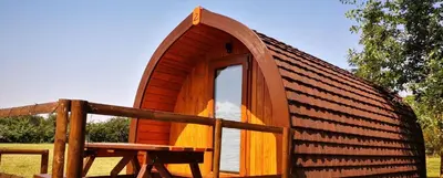 a small wooden cabin with a window and a bench at Cosy Camping Suffolk in Ipswich