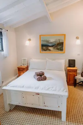 a bedroom with a white bed with two donuts on it at Creeksea Place Barns in Burnham on Crouch