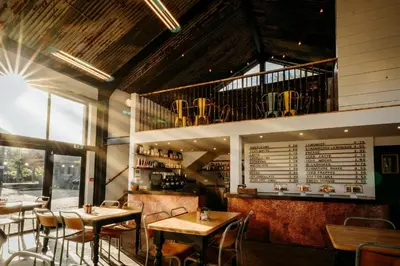 a restaurant with tables and chairs in a room at Creeksea Place Barns in Burnham on Crouch