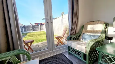 a porch with a chair and a sliding glass door at Airport Reach in Southend-on-Sea