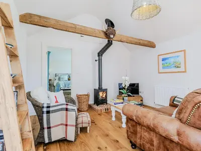 a living room with a couch and a wood stove at The Bull Pen in Lawford