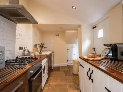 a large kitchen with a stove and a sink at Pebble Cottage in Aldeburgh