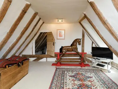 a living room with a horse statue in a attic at Thatched Cottage in Saxmundham