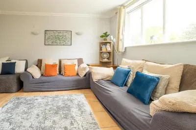 a living room with two couches with colorful pillows at 1 Hazelwood, Aldeburgh in Aldringham