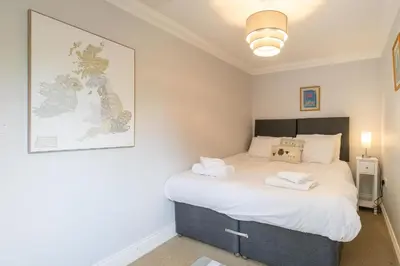 a small bedroom with a bed with white sheets at 1 Hazelwood, Aldeburgh in Aldringham