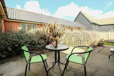 a patio with a table and two chairs at 1 Hazelwood, Aldeburgh in Aldringham