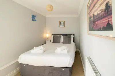 a bedroom with a large bed with white sheets at 1 Hazelwood, Aldeburgh in Aldringham