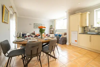 a kitchen and dining room with a table and chairs at 1 Hazelwood, Aldeburgh in Aldringham