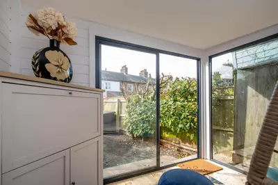 a living room with a large window with a view at Sleepers Cottage in Aldeburgh