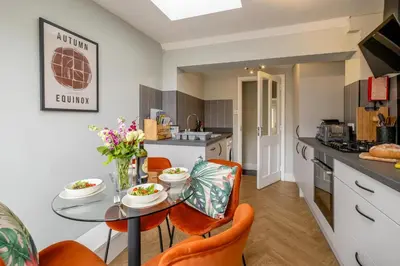 a kitchen and dining room with a table and chairs at Sleepers Cottage in Aldeburgh