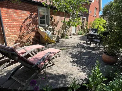 a patio with two lounge chairs and a table at Dairy Cottage Luxury B&B in Attleborough