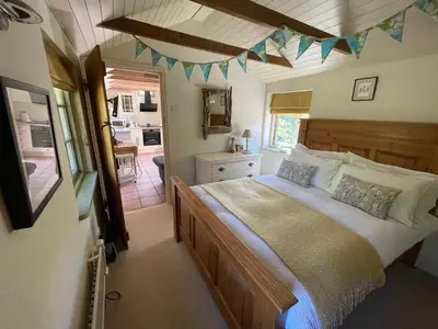 a bedroom with a large bed in a room at Dairy Cottage Luxury B&B in Attleborough