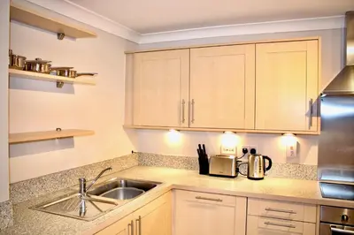 a kitchen with wooden cabinets and a sink at Mathus Gardens in Cambridge