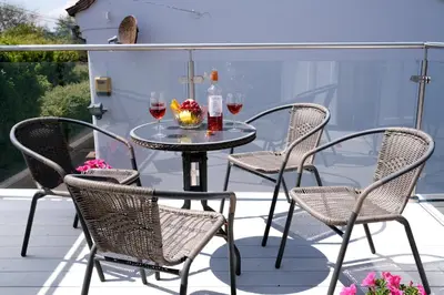 a table and chairs on a patio with wine glasses at Drift In in Aldeburgh