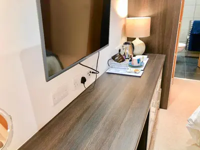 a large television on a wall in a hotel room at Laurels in Felsted