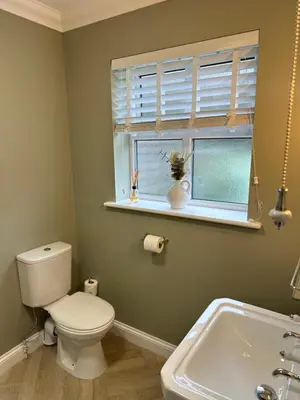a bathroom with a toilet and a window and a sink at Everglades in Denver
