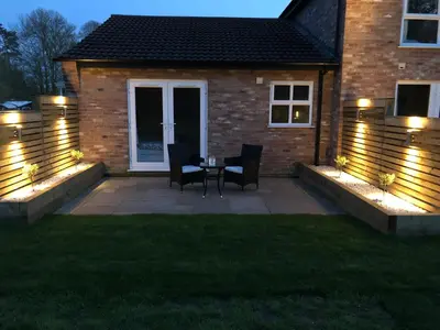a patio with a table and chairs and lights at Everglades in Denver