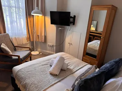 a bedroom with a bed with a mirror and a tv at Regency House in Cambridge