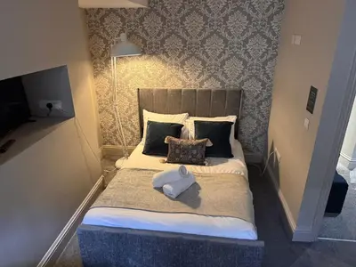 a small bedroom with a large bed with pillows at Regency House in Cambridge
