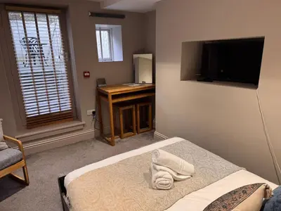 a bedroom with a bed and a desk and a television at Regency House in Cambridge