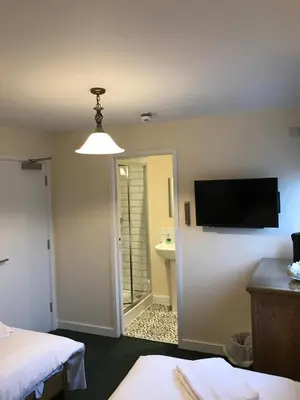 a room with a bed and a flat screen tv at The Dorrington in Halstead