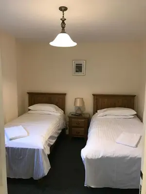 a room with two beds and a lamp in it at The Dorrington in Halstead