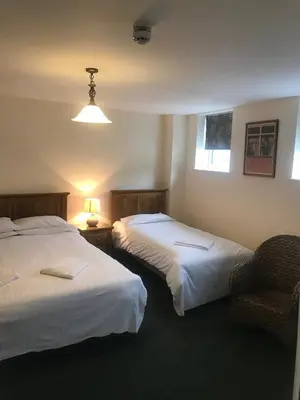 a hotel room with two beds and a chair at The Dorrington in Halstead
